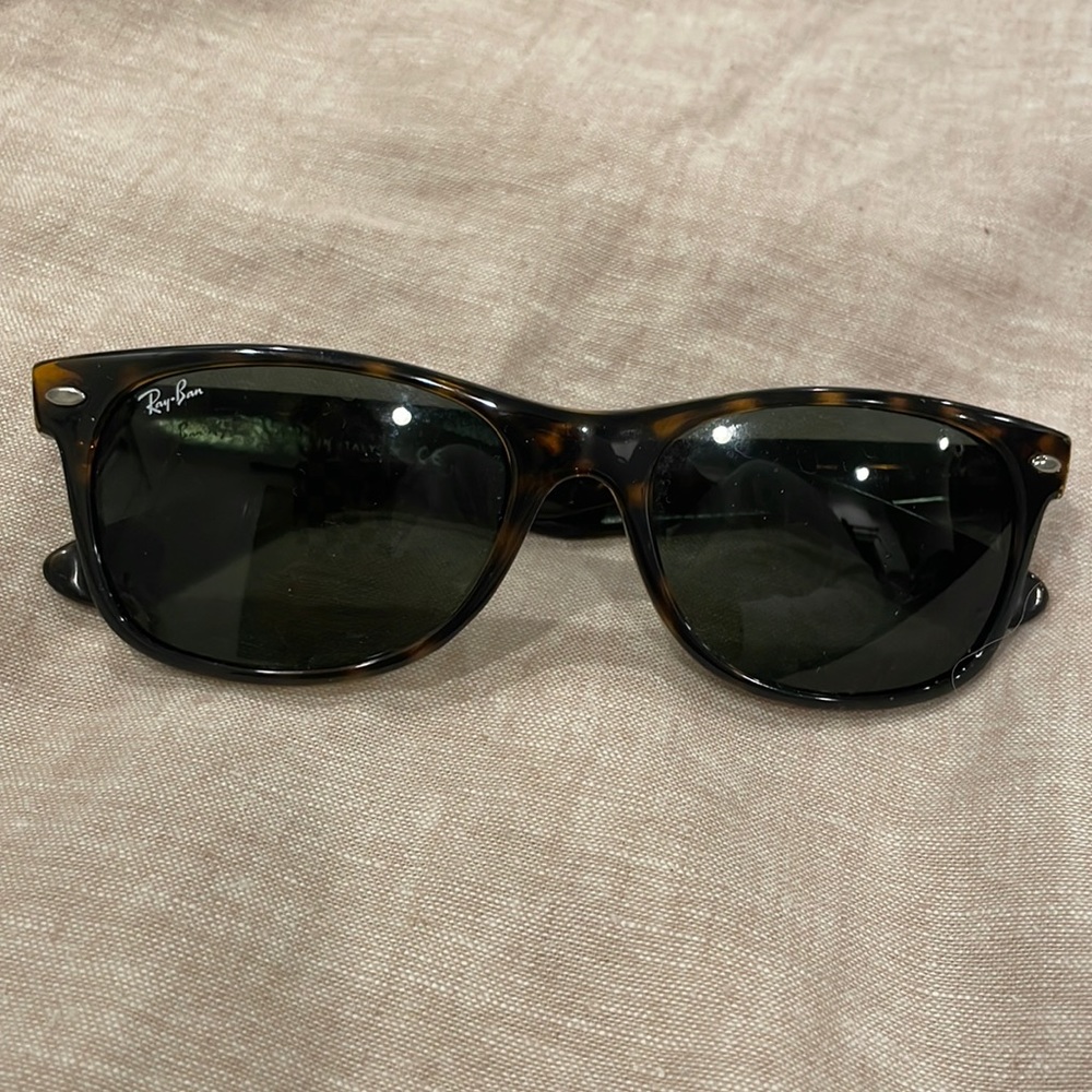 Ray Ban New Wayfarer sunglasses. There is a small scratch on the left lens